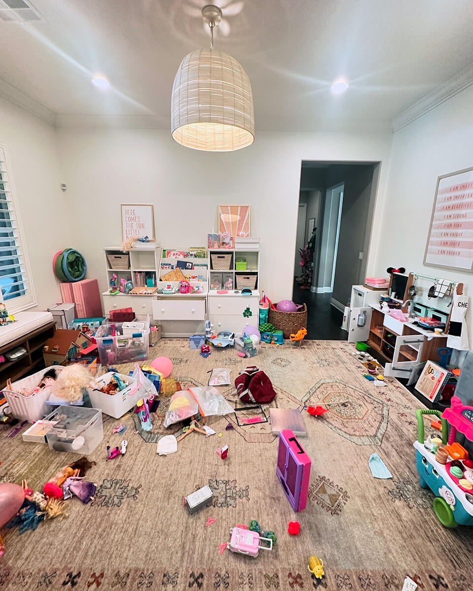 Cluttered children's playroom with scattered toys before professional home organizing in Las Vegas — overwhelmed parents needing zero-judgment support