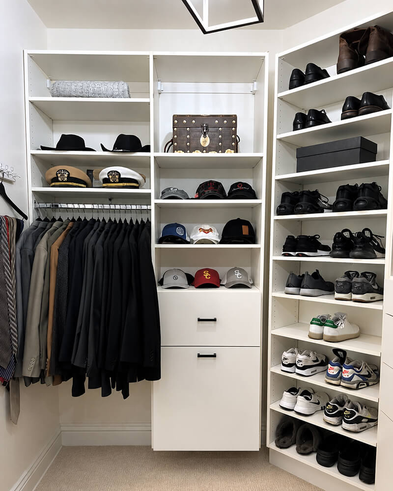 Professionally organized men's walk-in closet in Las Vegas by Lifelystyle — suits on the left rail, curated hat collection on center shelves, and a full sneaker library on the right