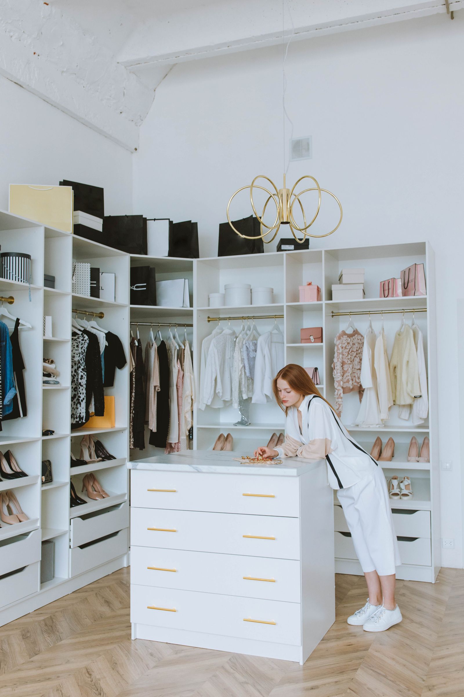 Organized luxury walk-in closet with neatly arranged clothing and shoes after professional organizing